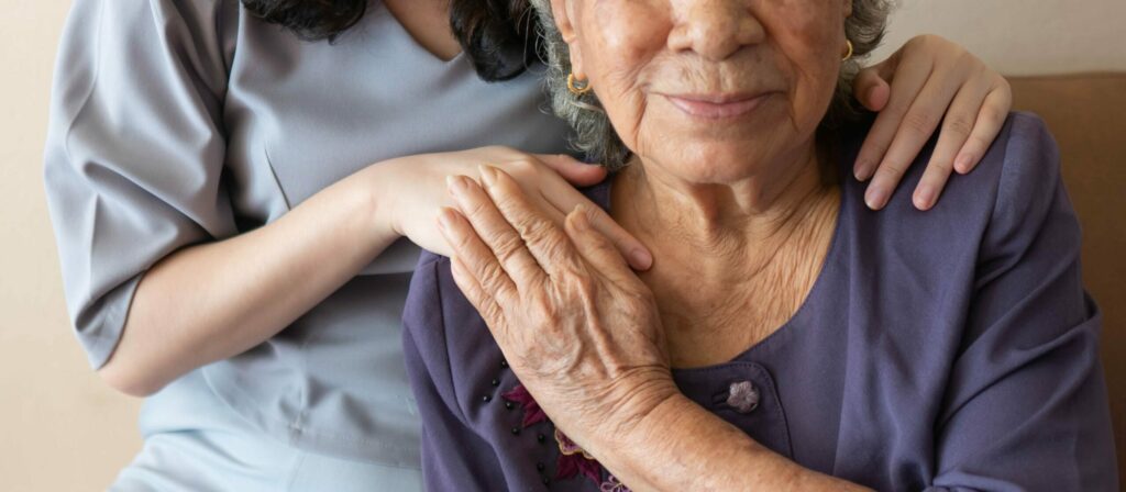 caregiver's hand on patient's shoulder